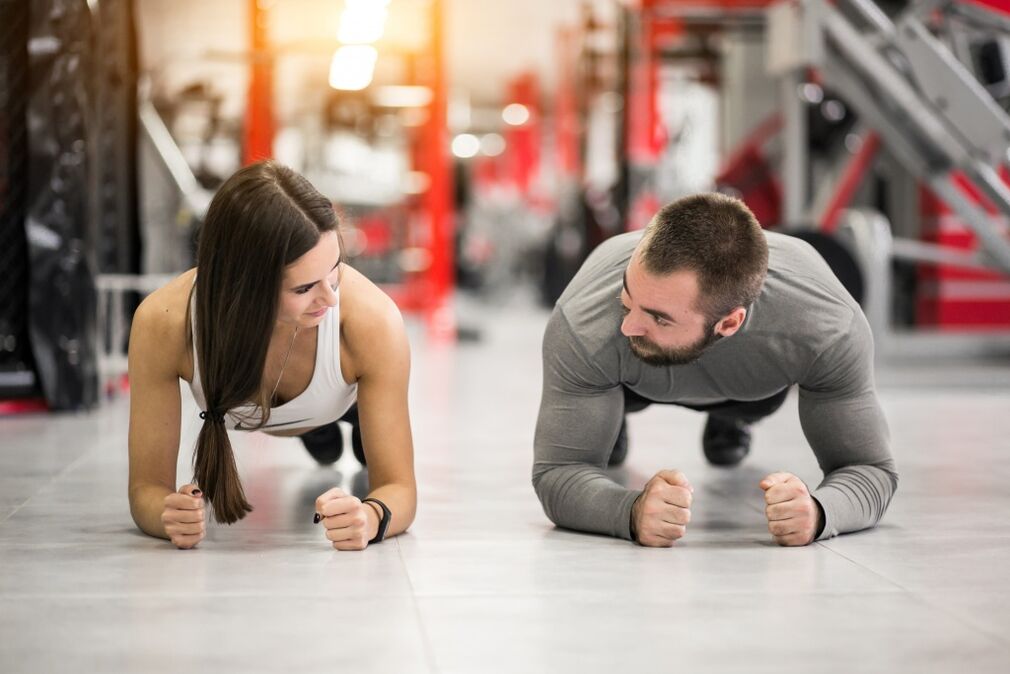 Маж и жена ја изведуваат вежбата Планк, наменета за сите мускулни групи